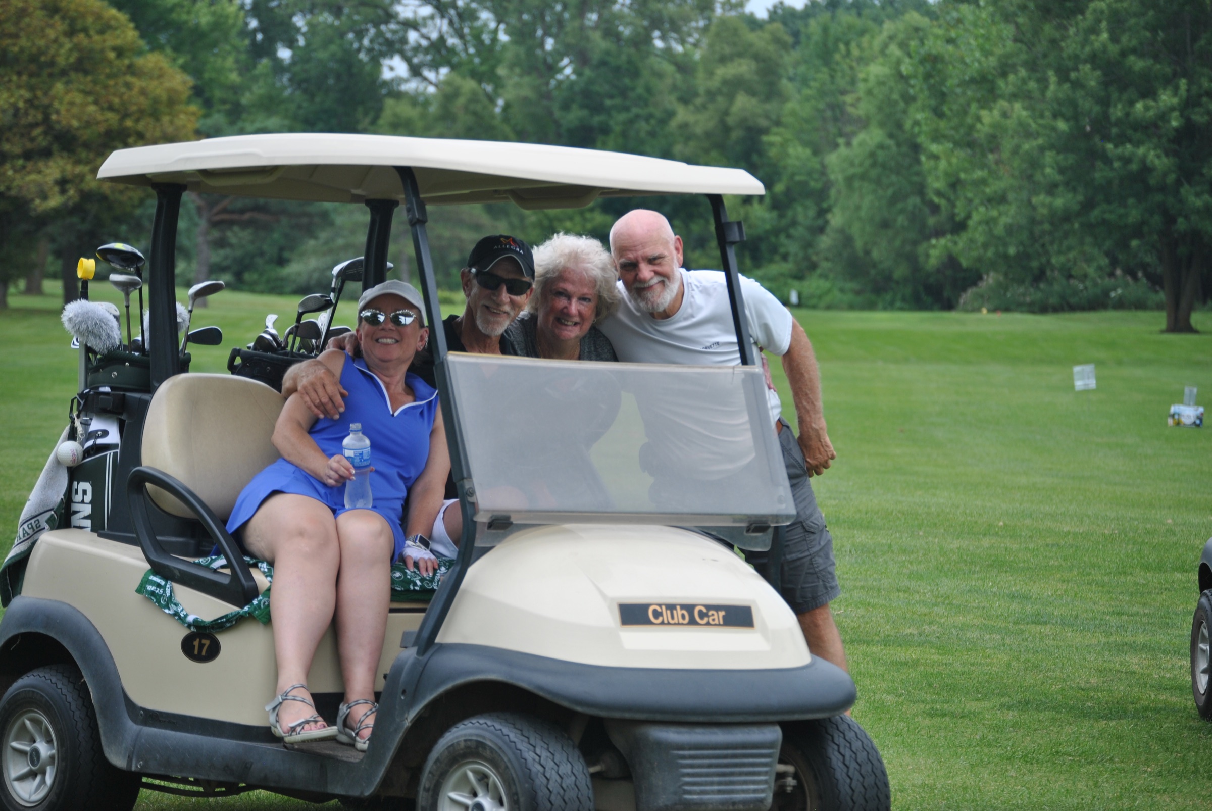 Golf outing guests smiling from a cart