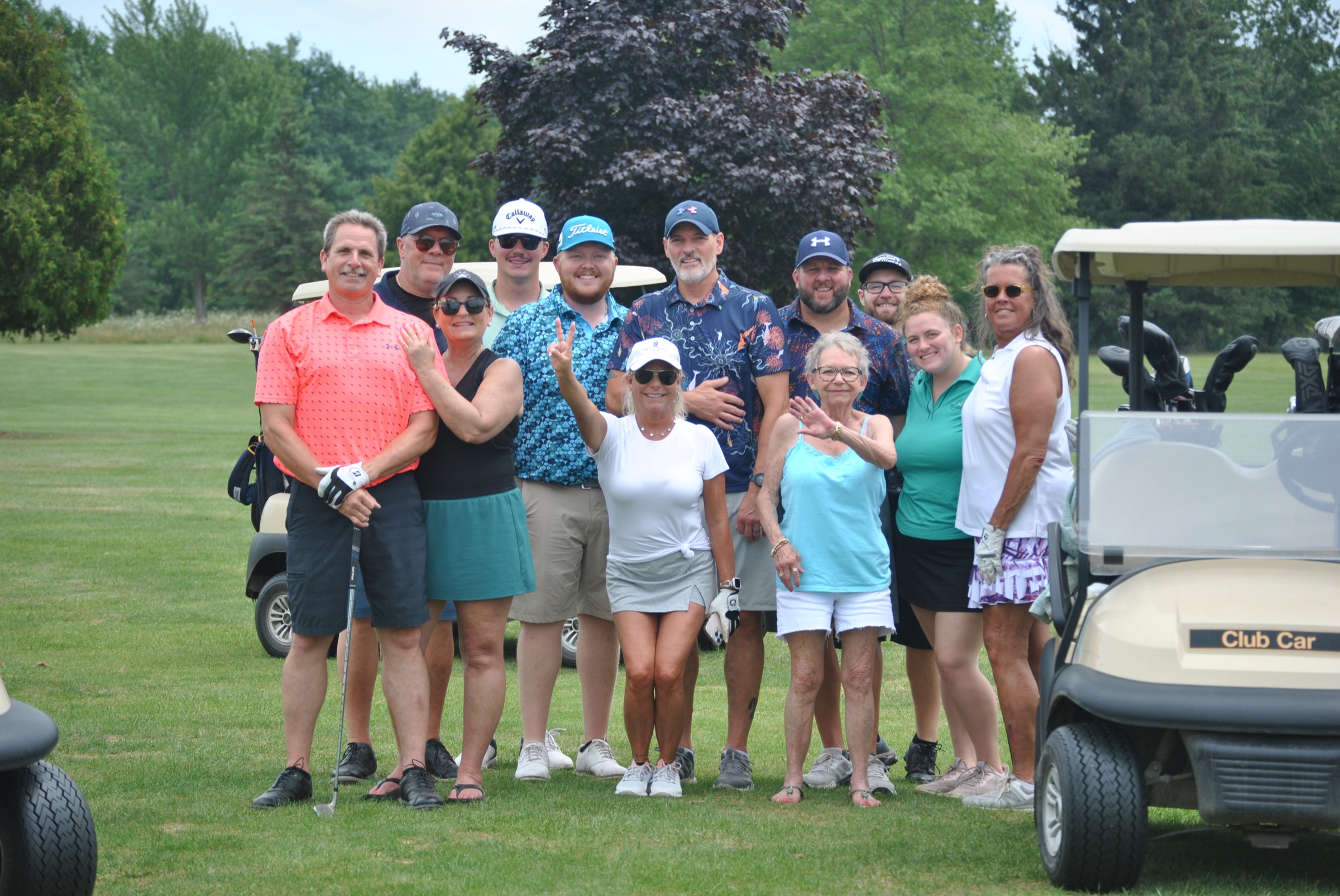 Outing group posing by golf carts